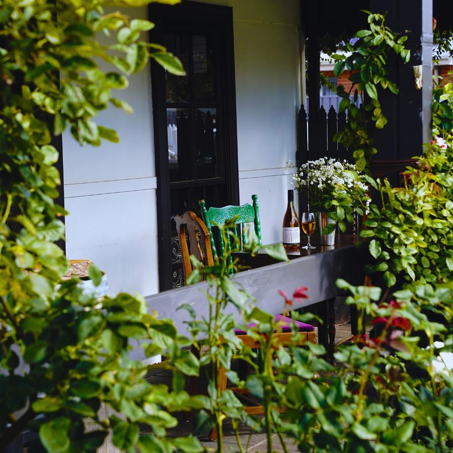 The Sapling Yard cellar door veranda at Aranya Acres, Wamboin, set with wine bottles and greenery
